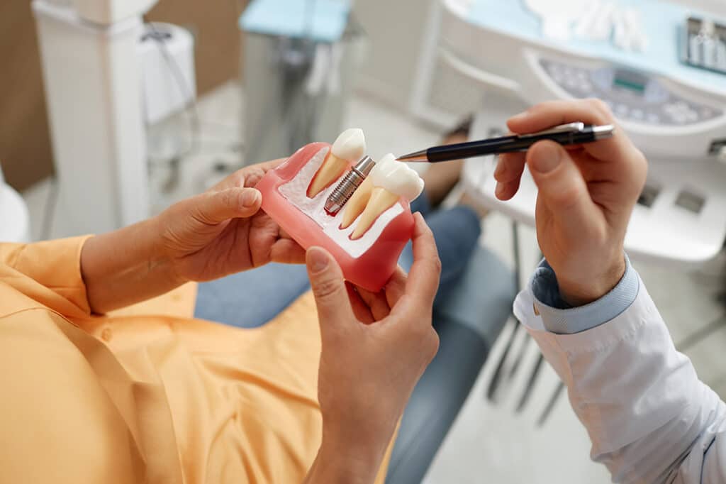 Patient being shown various dental implants